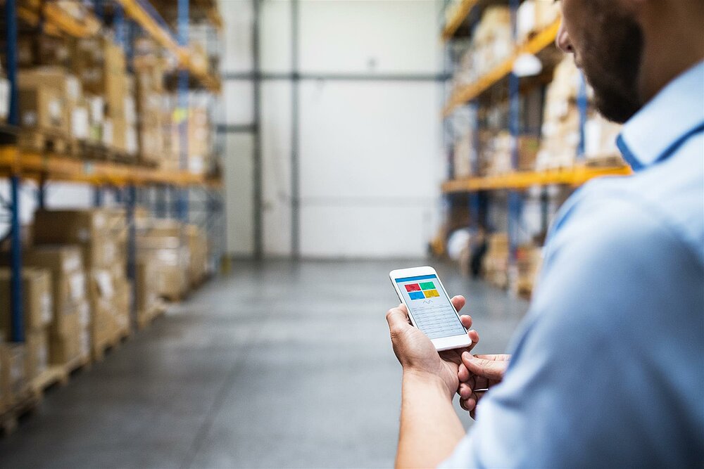 Photo of someone using an logistics management app in the warehouse